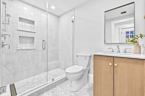 a bathroom with a sink a toilet and shower