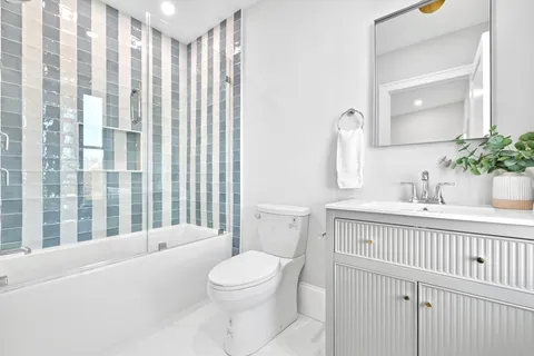 a bathroom with a sink a toilet a mirror and shower