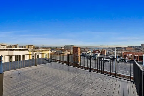 a view of roof deck with two chairs and wooden floor