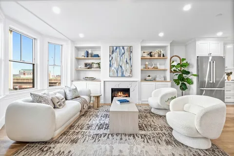 a living room with furniture a fireplace and a large window