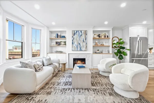 a living room with furniture a fireplace and a large window