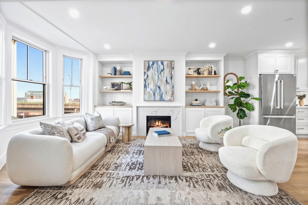 12 Prospect Street, Unit 2 Boston, MA 02129 - Photo 8 of 27 a living room with furniture a fireplace and a large window