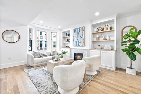 a living room with furniture a fireplace and a potted plant