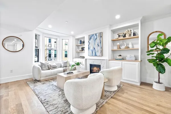 a living room with furniture a fireplace and a potted plant