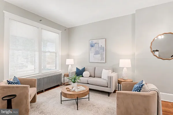 a living room with furniture a chandelier and wooden floor