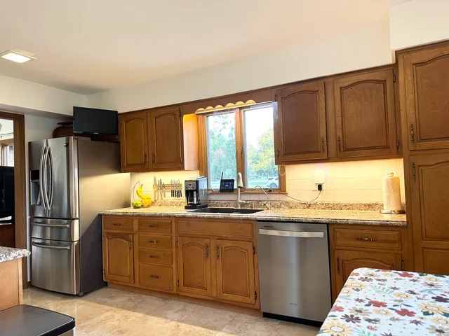 a kitchen with stainless steel appliances granite countertop a stove refrigerator and a sink
