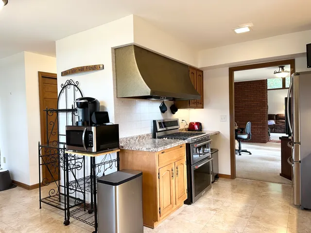a kitchen with a stove and a wooden floor