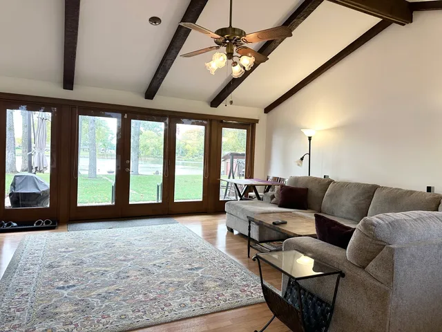 a view of a livingroom with furniture hardwood floor and a large window