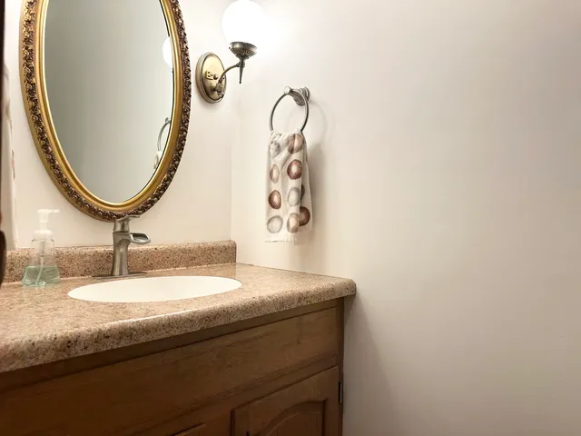 a bathroom with a granite countertop sink and mirror