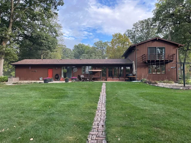 a front view of a house with a yard table and tree