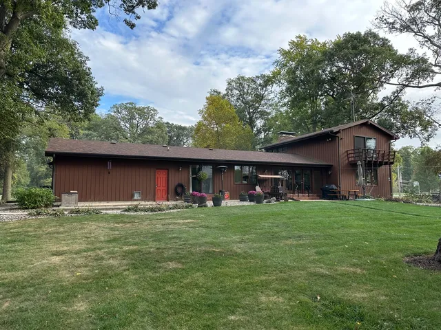 a view of a house with a yard tree and sitting area