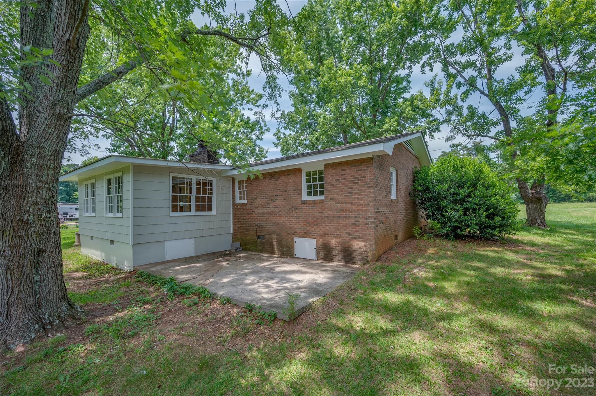1034 Old Stonecutter Road Rutherfordton, NC 28139 - Photo 23 of 27 a backyard of a house with large trees and brick walls
