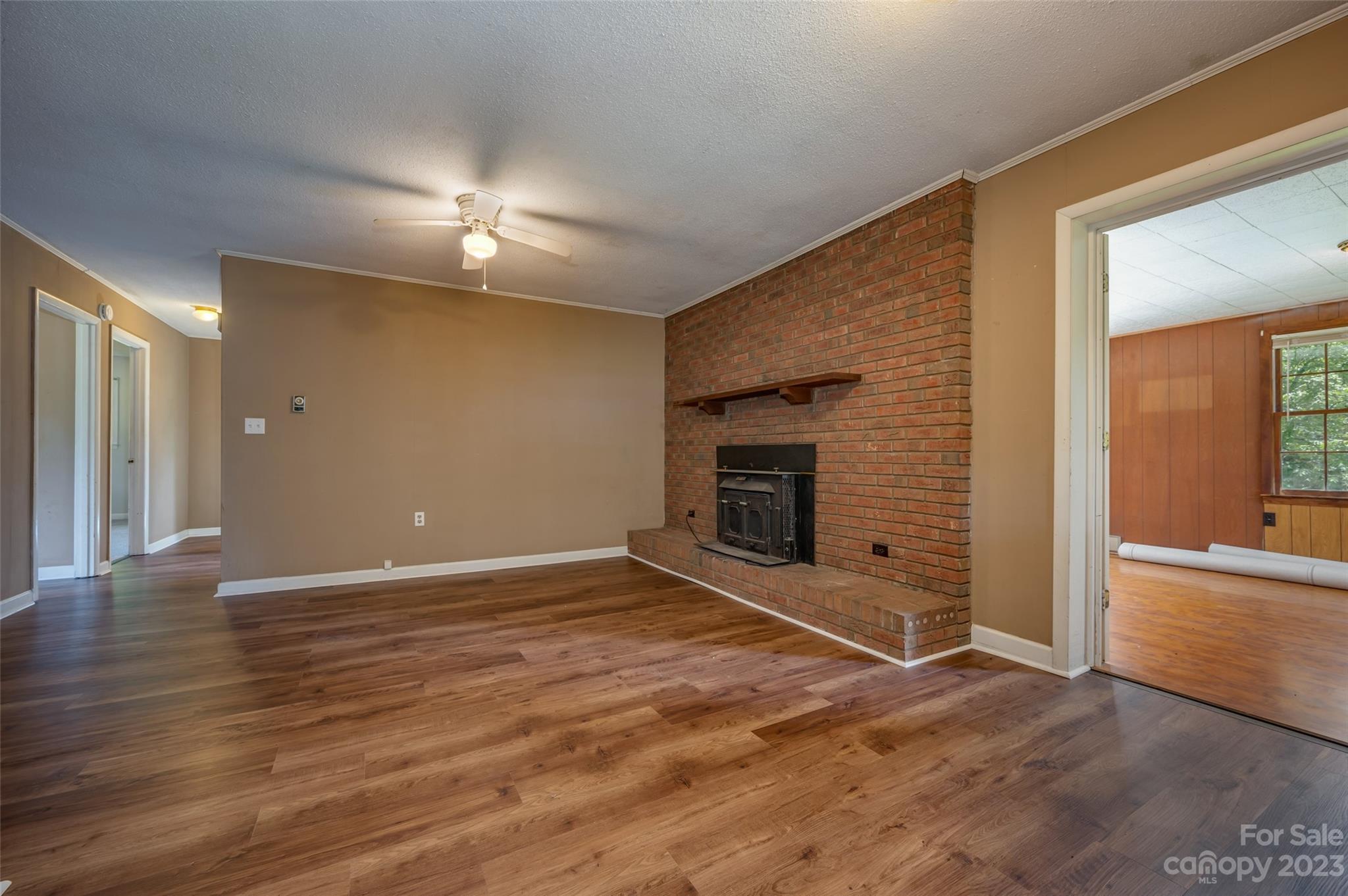 1034 Old Stonecutter Road Rutherfordton, NC 28139 - Photo 5 of 27 an empty room with wooden floor and fireplace