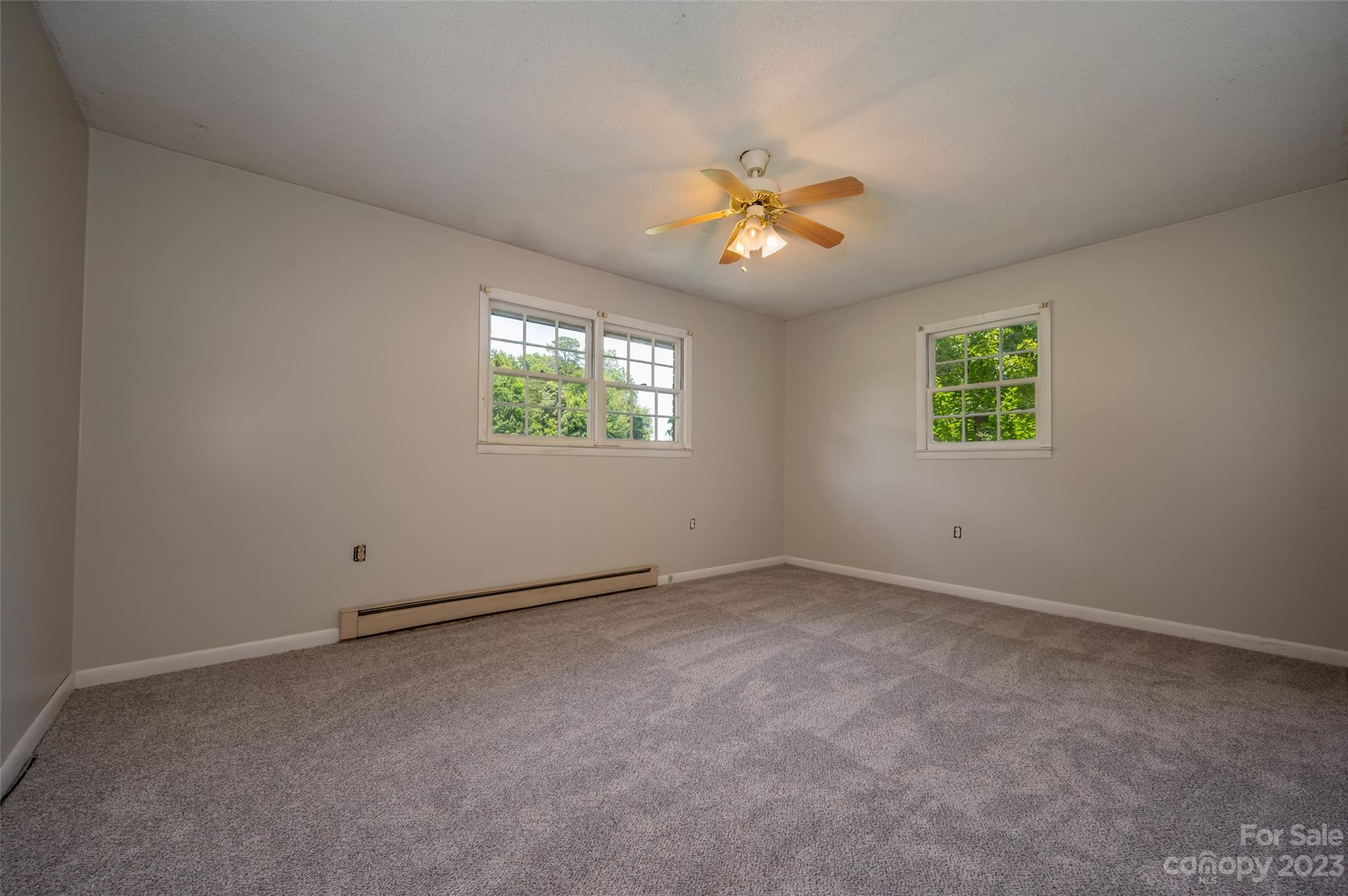 1034 Old Stonecutter Road Rutherfordton, NC 28139 - Photo 8 of 27 an empty room with windows and chandelier fan