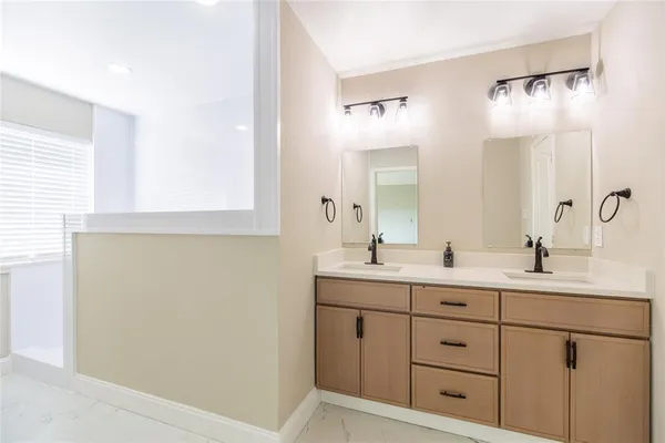 a bathroom with a double vanity sink and mirror