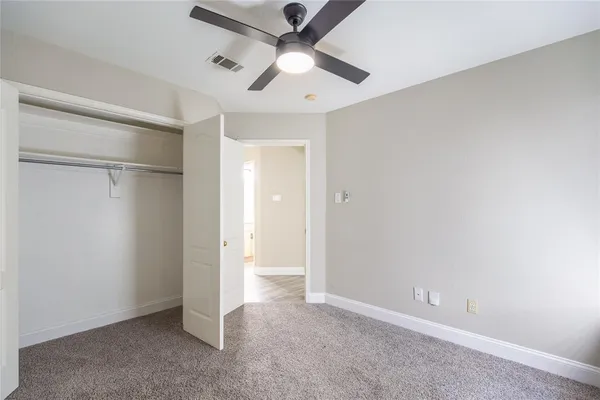 an empty room with a ceiling fan and a window