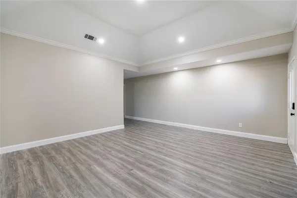 a view of an empty room with wooden floor