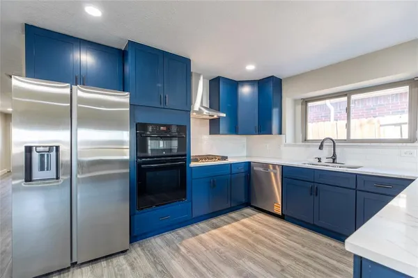 a kitchen with stainless steel appliances granite countertop a refrigerator a sink a stove and oven
