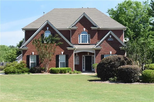 a front view of a house with a garden