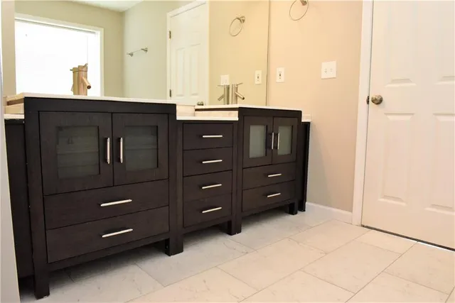 a bathroom with a granite countertop sink vanity and mirror