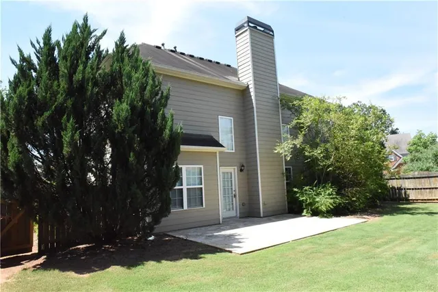 a front view of a house with yard and green space