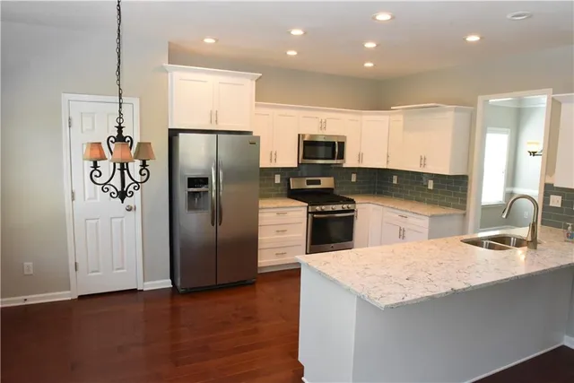 a kitchen with kitchen island granite countertop stainless steel appliances cabinets a sink and a center island
