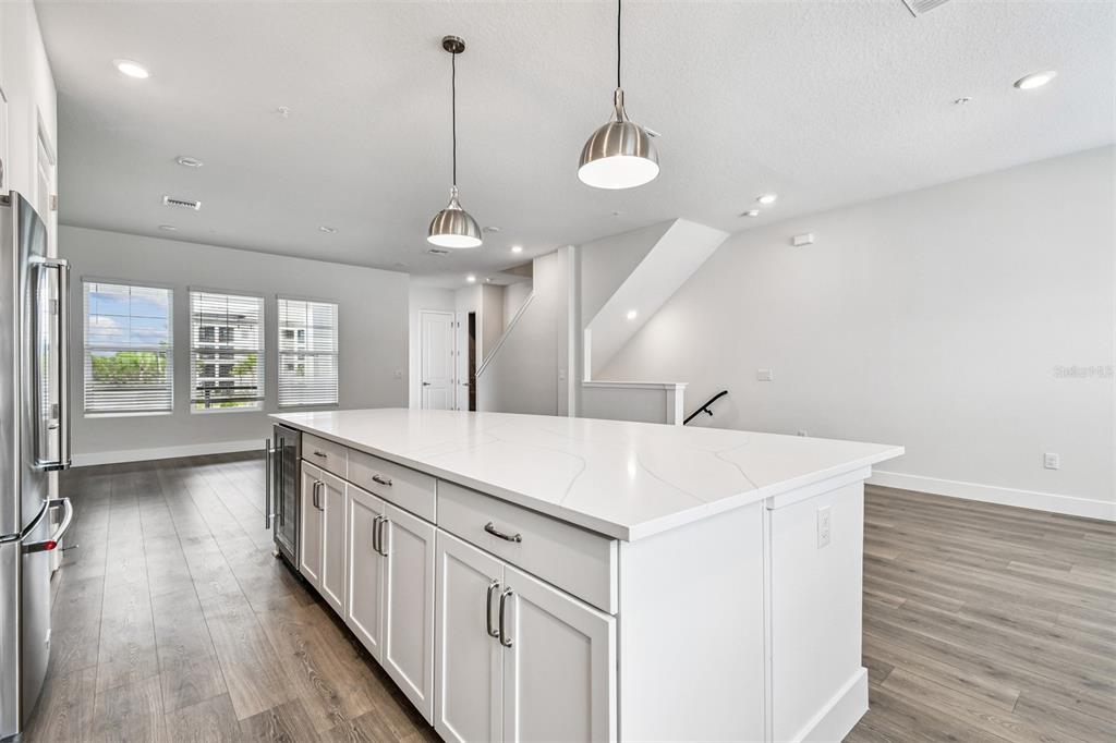 7204 Sutton Lane Sarasota, FL 34240 - Photo 13 of 47 a large white kitchen with a large island oven a stove and a wooden floors