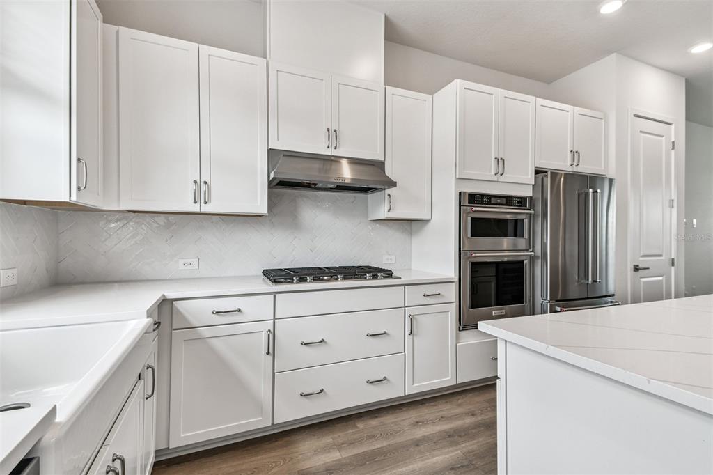 7204 Sutton Lane Sarasota, FL 34240 - Photo 14 of 47 a kitchen with stainless steel appliances white cabinets and a refrigerator