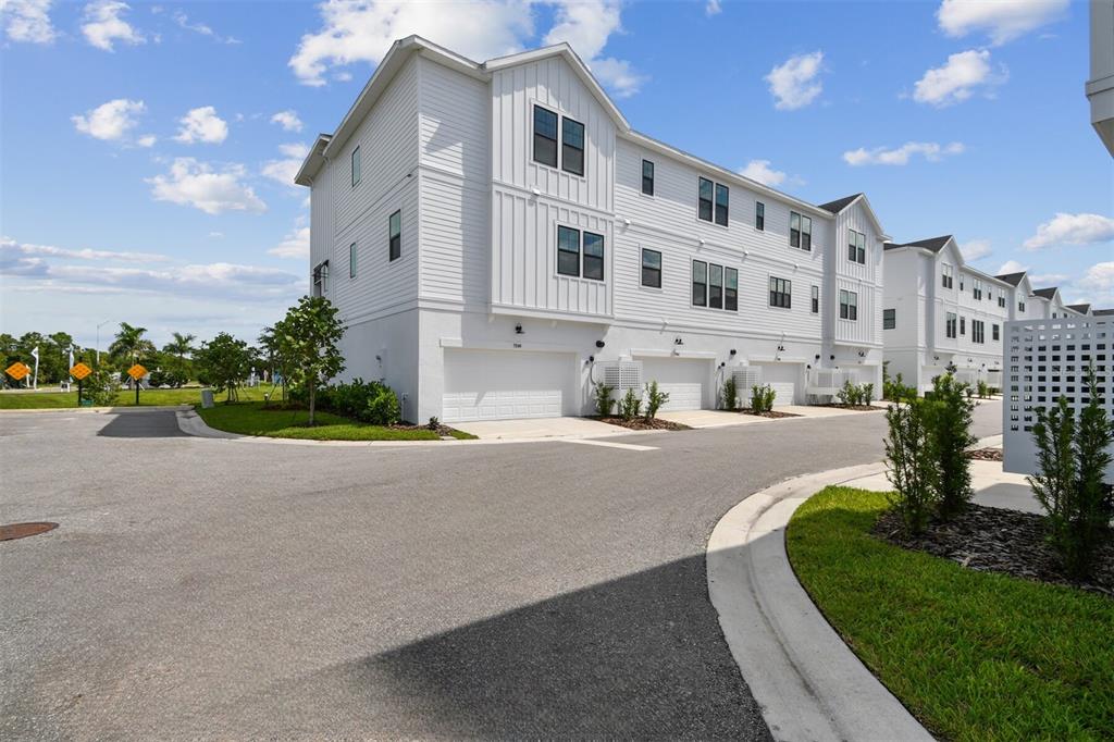 7204 Sutton Lane Sarasota, FL 34240 - Photo 44 of 47 a front view of a building with a garden and plants