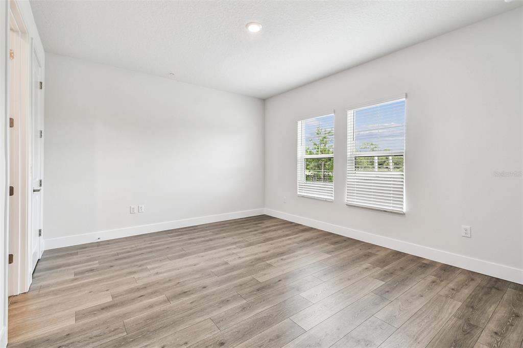 7204 Sutton Lane Sarasota, FL 34240 - Photo 7 of 47 an empty room with wooden floor and windows