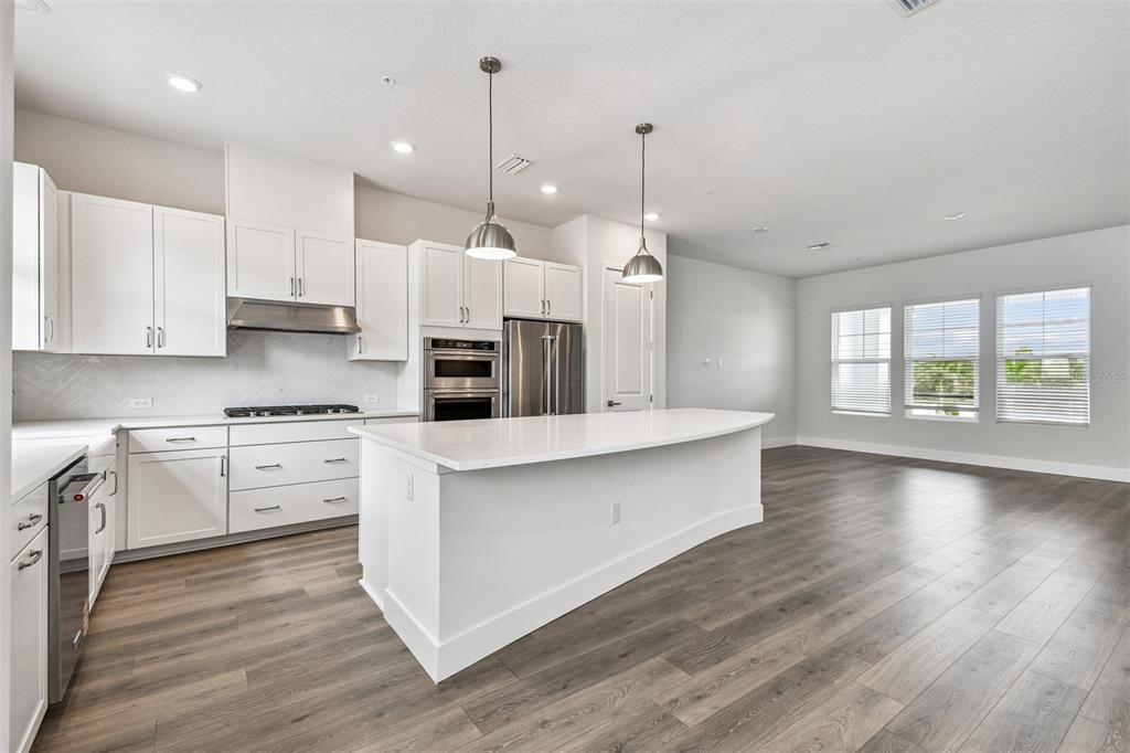 7204 Sutton Lane Sarasota, FL 34240 - Photo 10 of 47 a large kitchen with cabinets wooden floor and a window