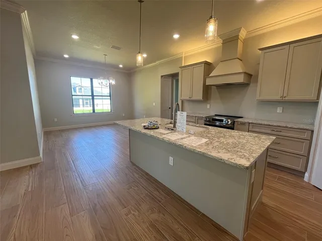 a kitchen with kitchen island granite countertop a sink window and wooden floor