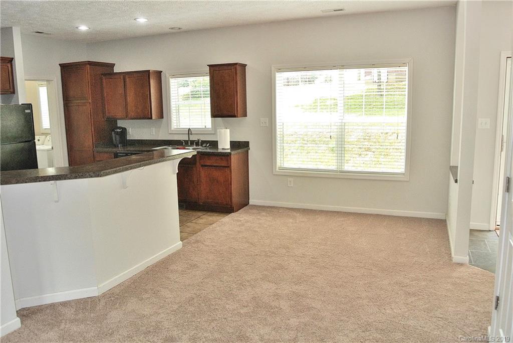 335 Upper Thomas Branch Road Marshall, NC 28753 - Photo 4 of 22 a large kitchen with kitchen island granite countertop a stove a sink a refrigerator and blue cabinets with wooden floor