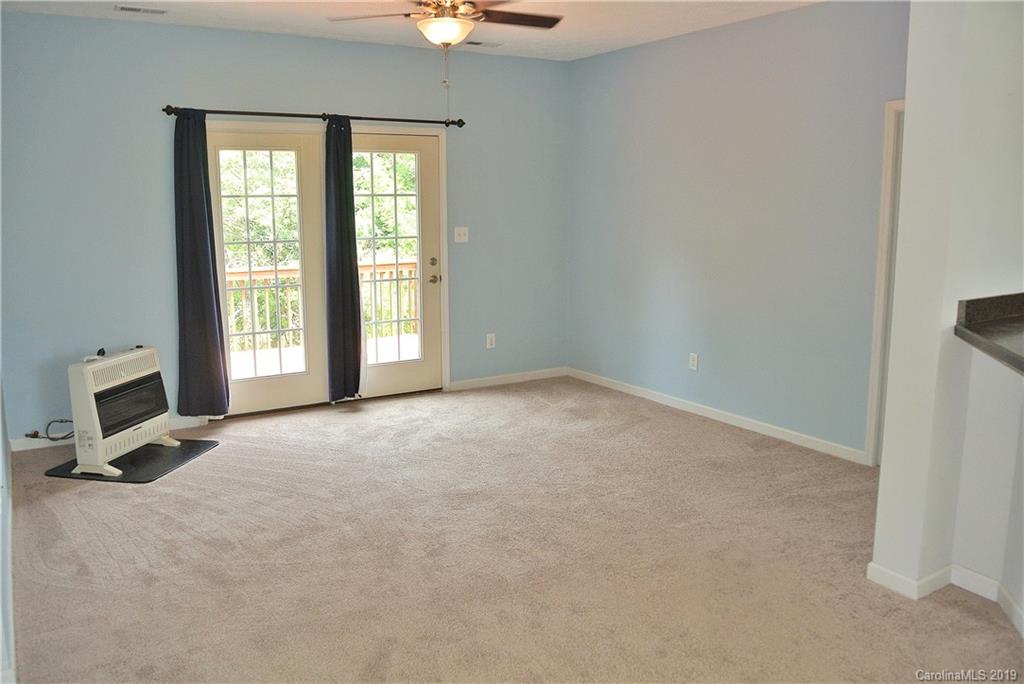 335 Upper Thomas Branch Road Marshall, NC 28753 - Photo 9 of 22 an empty room with a fireplace and windows