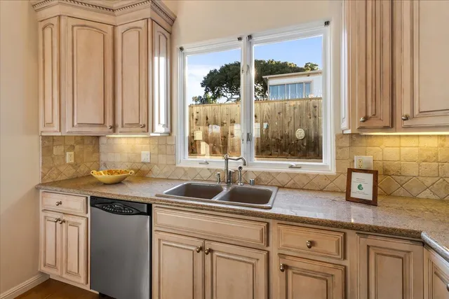 a kitchen with granite countertop a sink and a white cabinets