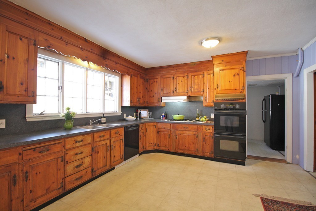 68 County Road, Unit 1 Ipswich, MA 01938 - Photo 15 of 22 a kitchen with stainless steel appliances granite countertop wooden cabinets a sink dishwasher a stove and a refrigerator with wooden floor