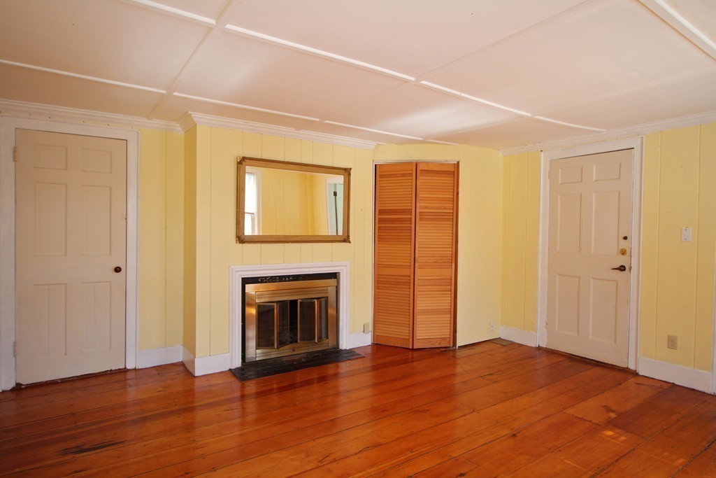 68 County Road, Unit 1 Ipswich, MA 01938 - Photo 16 of 22 an empty room with wooden floor fireplace and windows