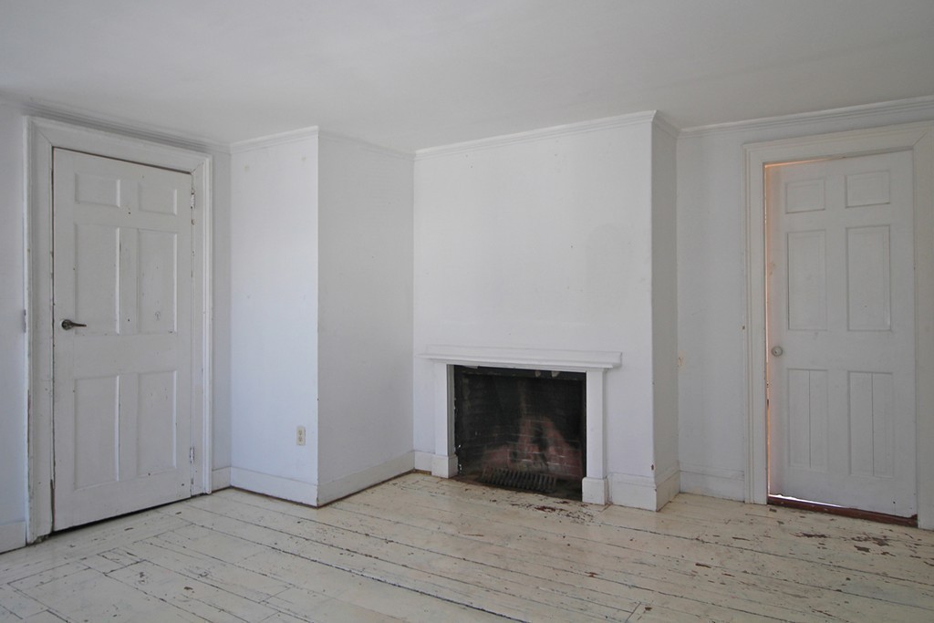 68 County Road, Unit 1 Ipswich, MA 01938 - Photo 18 of 22 a view of an empty room with wooden floor and a fireplace