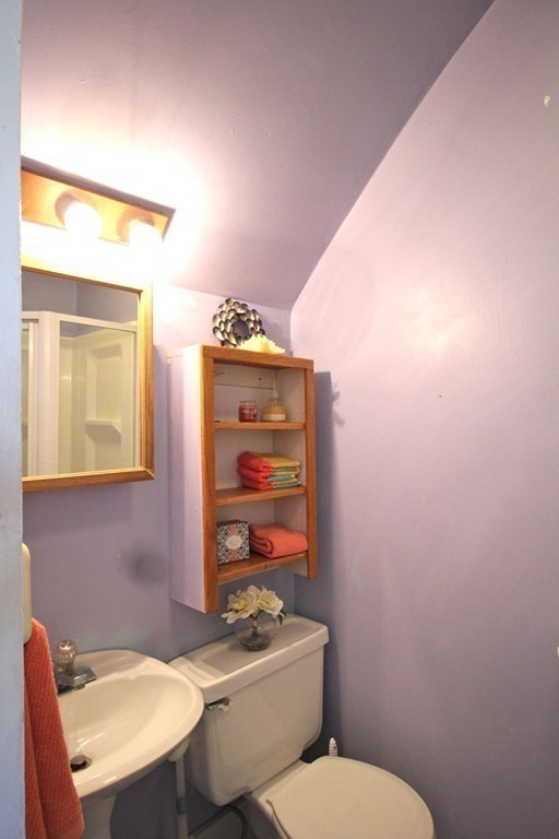 68 County Road, Unit 1 Ipswich, MA 01938 - Photo 20 of 22 a bathroom with a toilet a sink and mirror