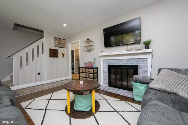 a living room with furniture a flat screen tv and a fireplace