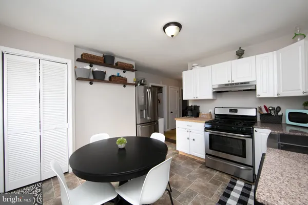 a kitchen with stainless steel appliances granite countertop a stove a refrigerator and a microwave
