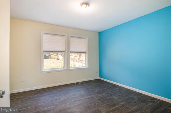 a view of a dry yard with trees in the background