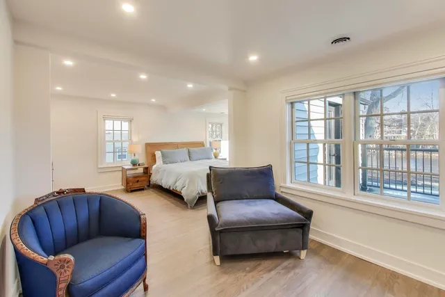a bedroom with furniture and a large window