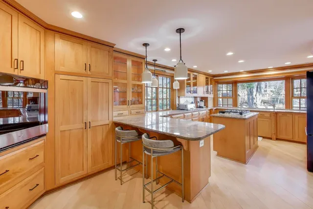 a kitchen with stainless steel appliances granite countertop a sink and a refrigerator