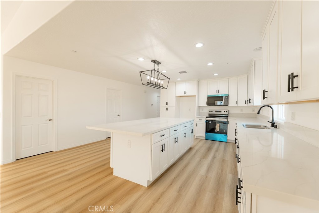 16925 Nanticoke Road Apple Valley, CA 92307 - Photo 27 of 87 a large kitchen with granite countertop a large counter top space a sink stainless steel appliances and cabinets