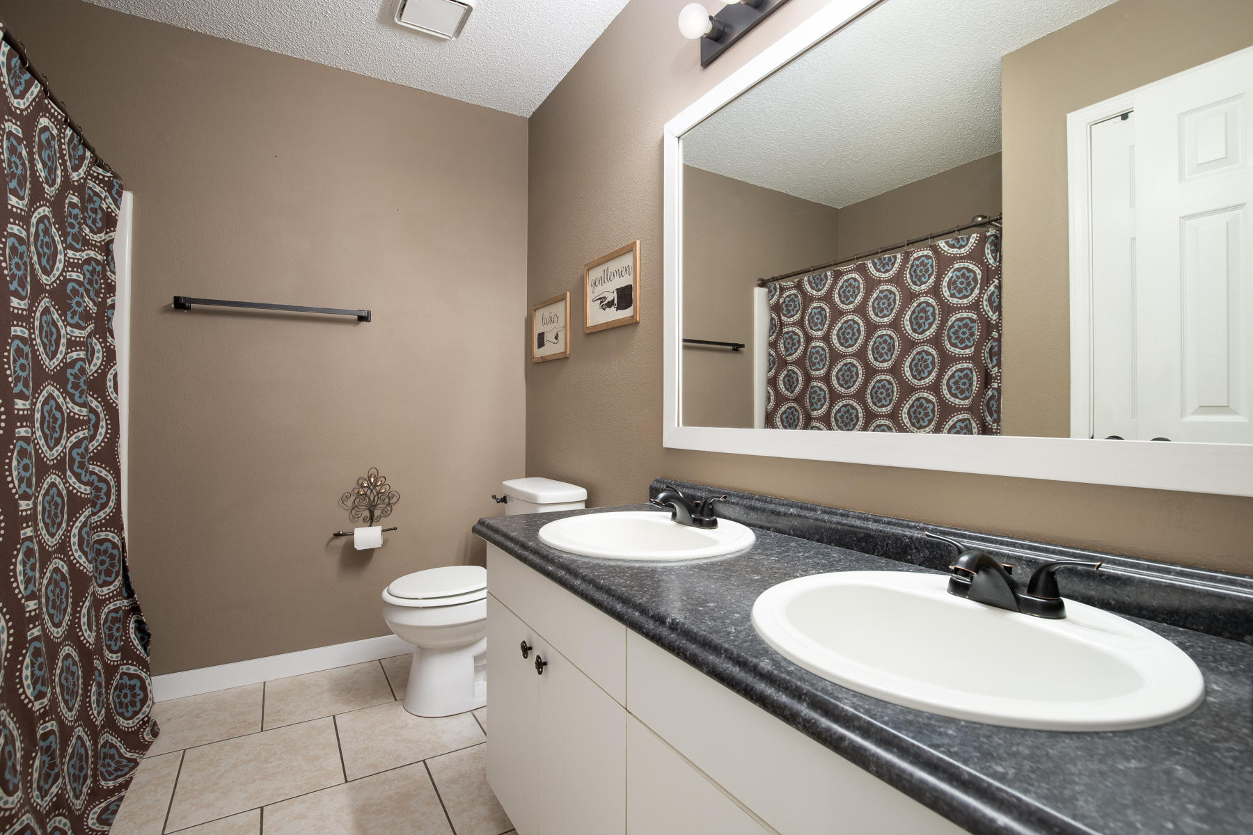 2774 Augustus Road Navarre, FL 32566 - Photo 11 of 18 a bathroom with a granite countertop sink toilet a mirror and shower