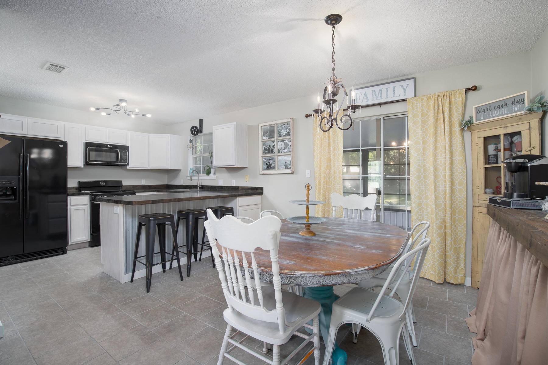 2774 Augustus Road Navarre, FL 32566 - Photo 5 of 18 a dining room with kitchen island a table and chairs