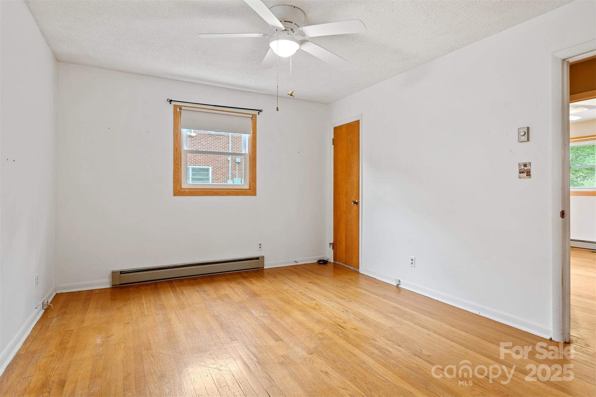 1405 8th Avenue Northwest Conover, NC 28613 - Photo 22 of 41 an empty room with a ceiling fan and wooden floor