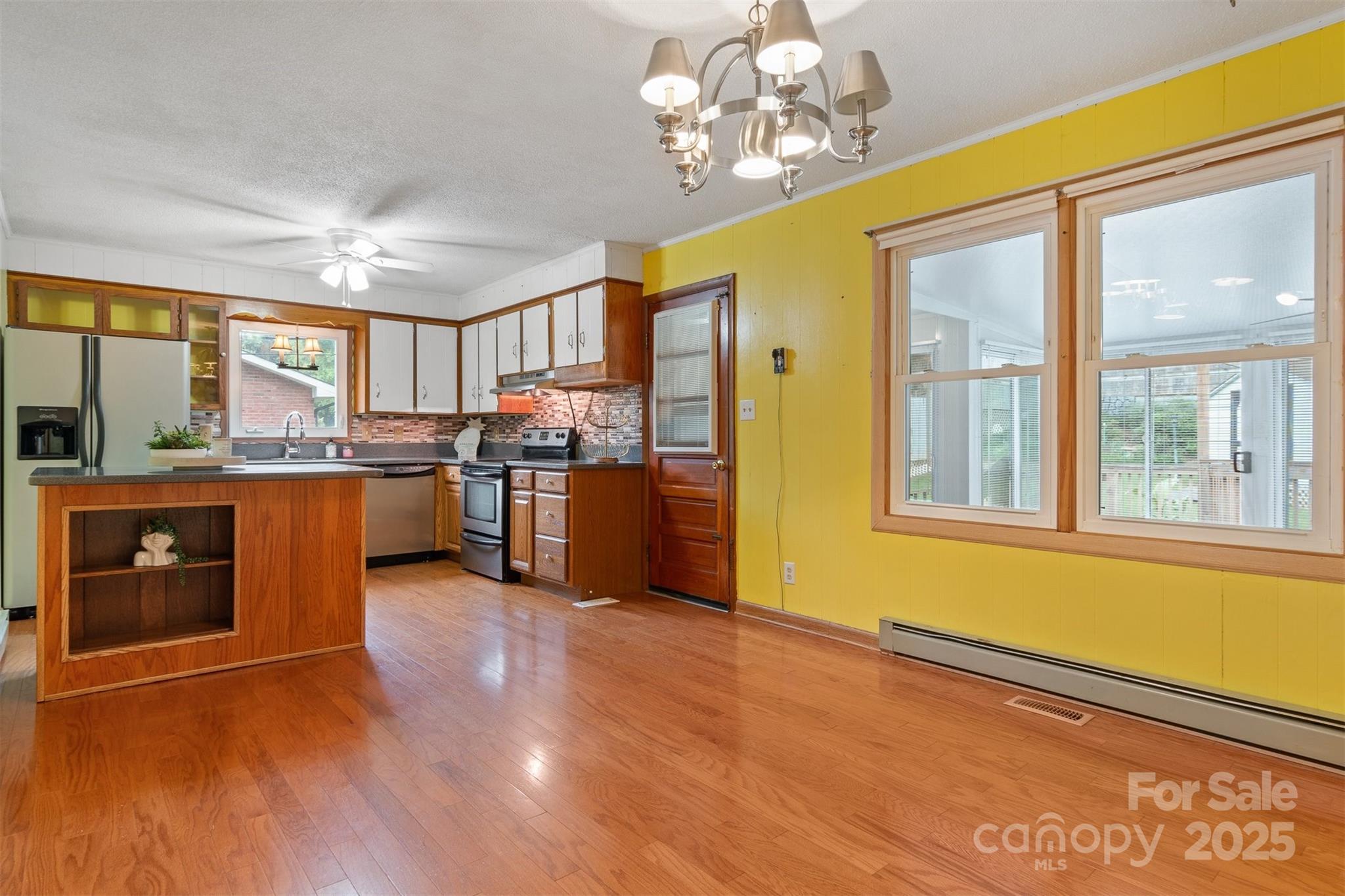 1405 8th Avenue Northwest Conover, NC 28613 - Photo 7 of 41 a open kitchen with stainless steel appliances granite countertop a stove top oven a sink dishwasher a dining table and chairs with wooden floor