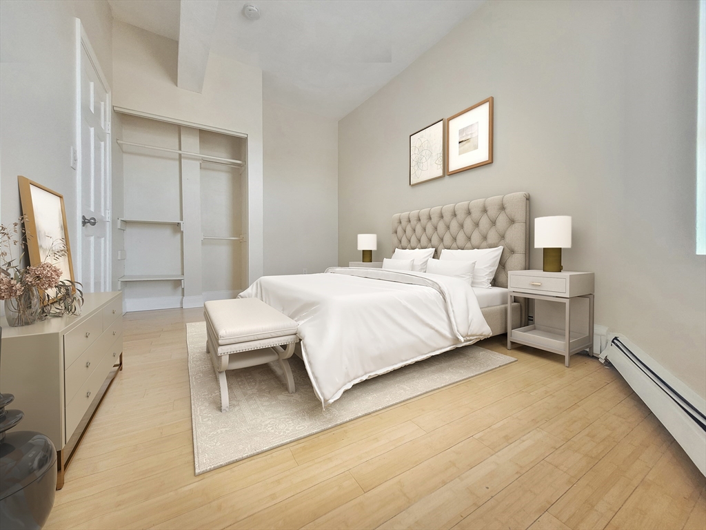 338-342 Warren Street, Unit 3 Boston, MA 02119 - Photo 3 of 7 a bedroom with a bed and a flat screen tv